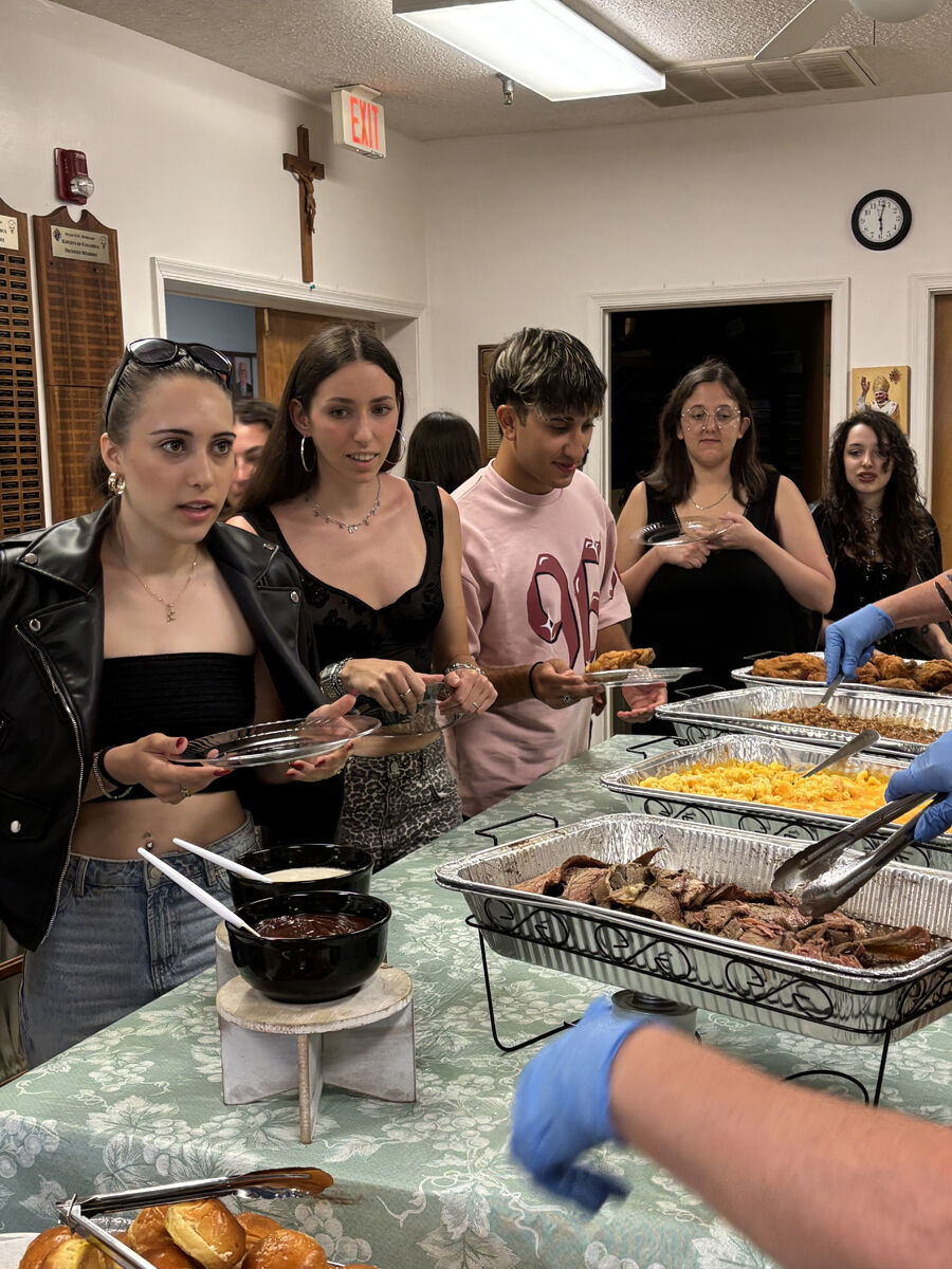 Five people standing in front of a buffet